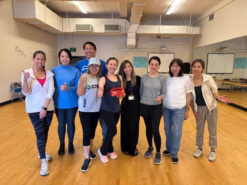 A group of teachers and staff posing together after receiving mooncakes ahead of the Mid-Autumn Festival.